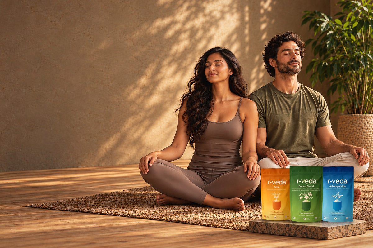 Two people meditating beside r-veda Amla, Baba's Blend and Ashwagandha pouches